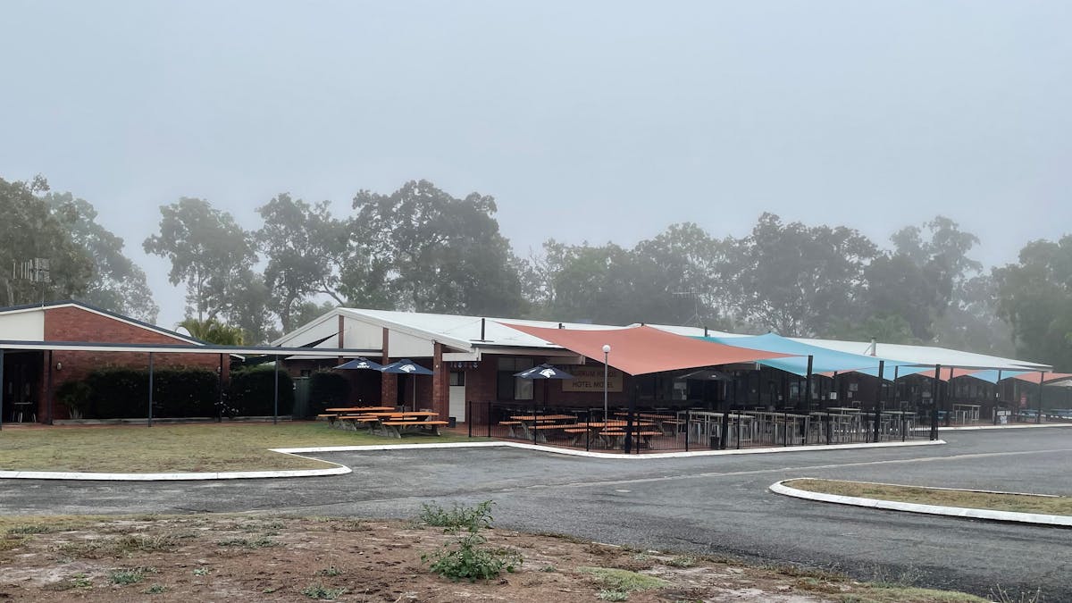photo showing Burrum Heads Hotel Motel facade with outdoor seating area on a foggy morning
