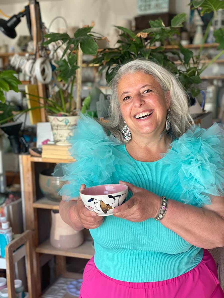 Picture of smiling woman holding a ceramic bowl.