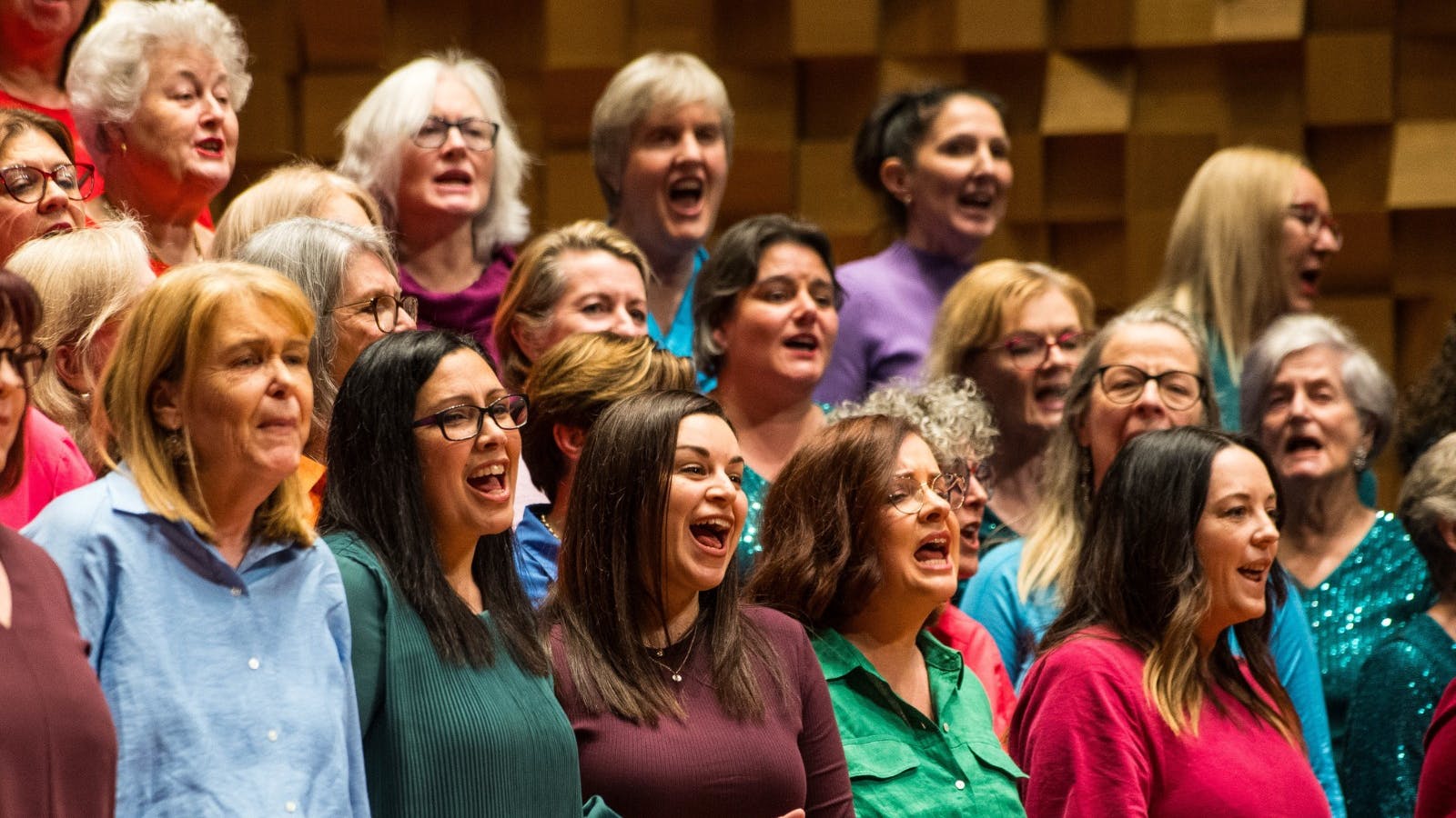 Members of an a cappella choir workshop singing with enthusiasm and passion