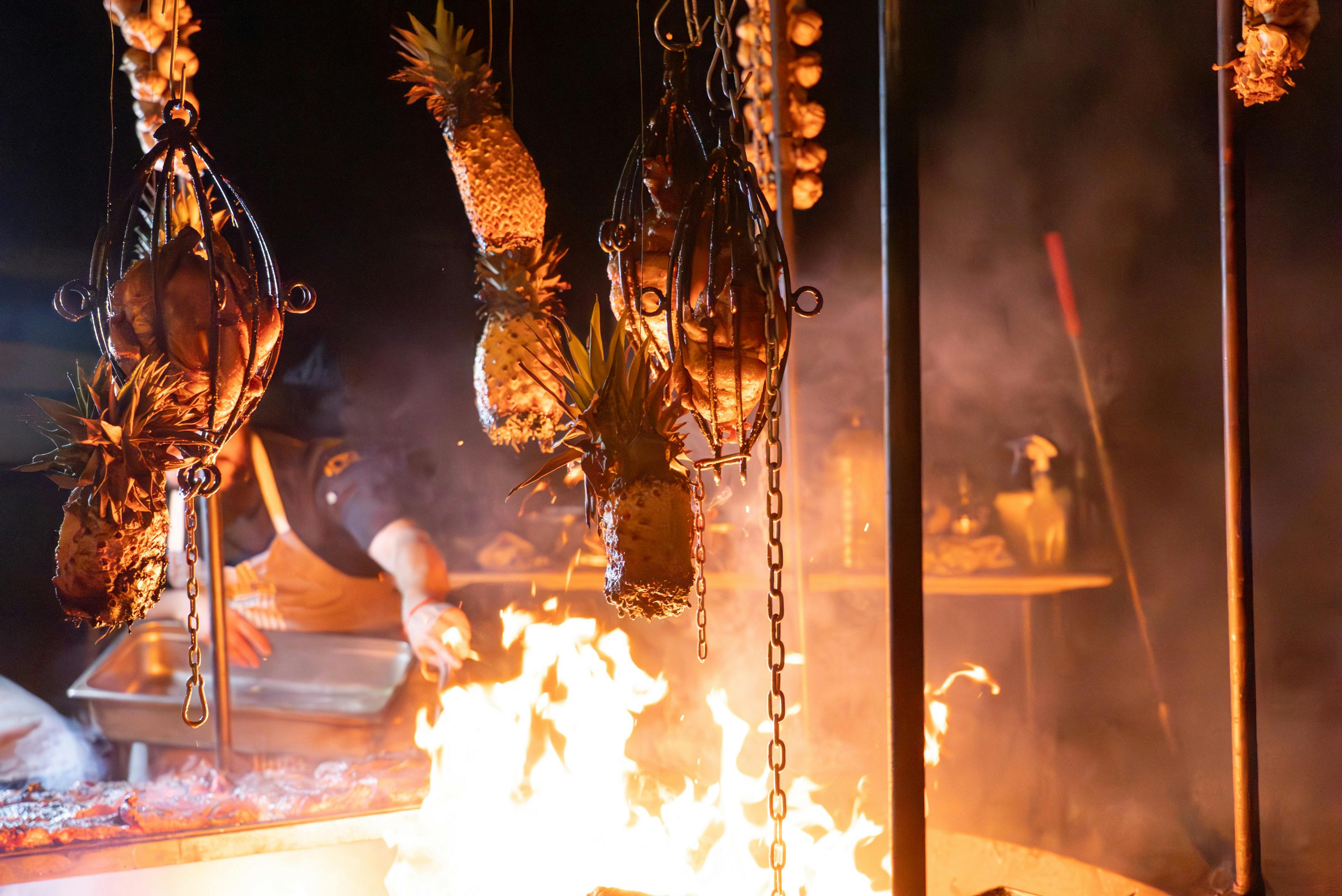 Chickens and Pineapple grilling over the open BBQ flame