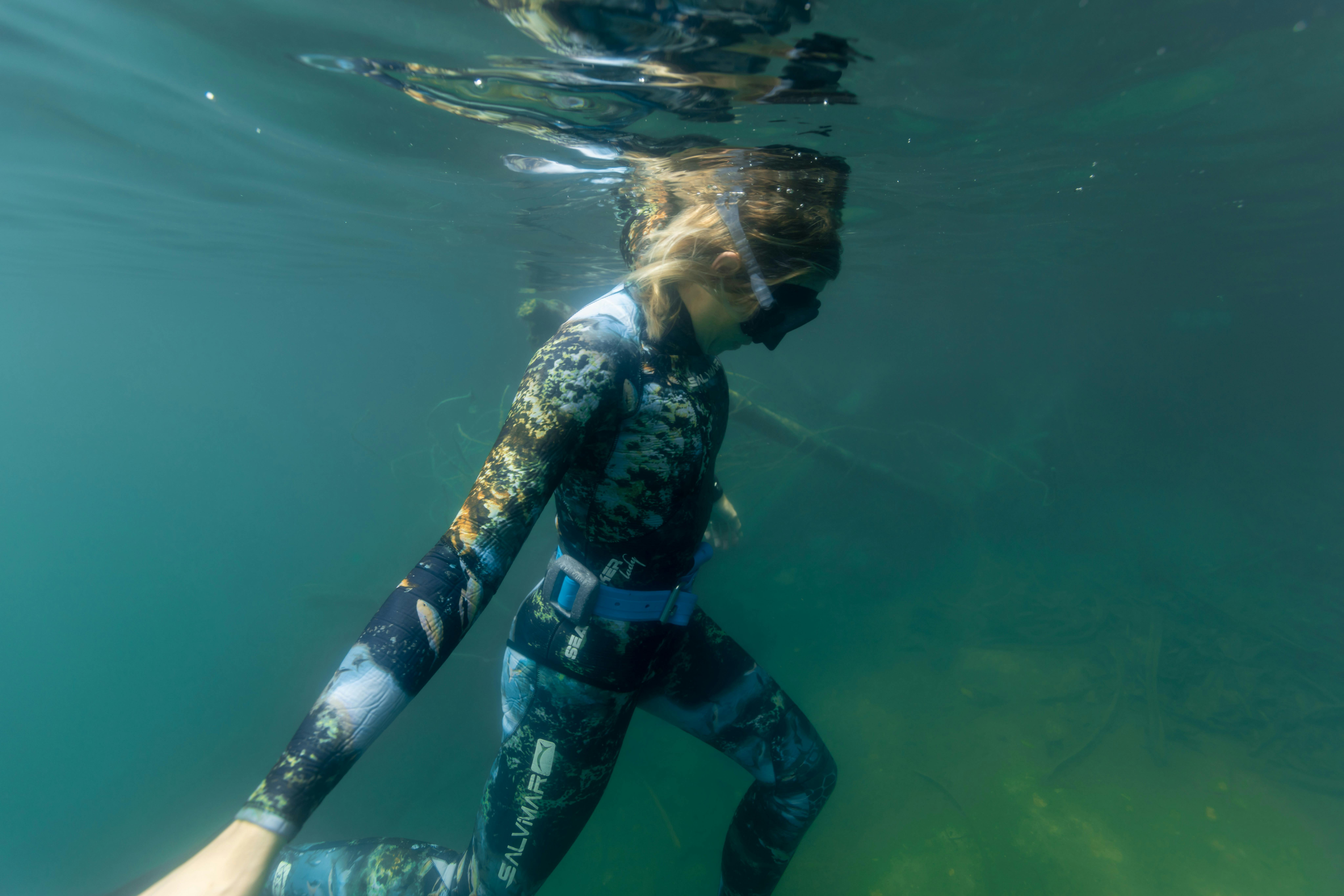Freediver is under the surface, holding her breath in Lake Eacham, Volcanic Crater Lake