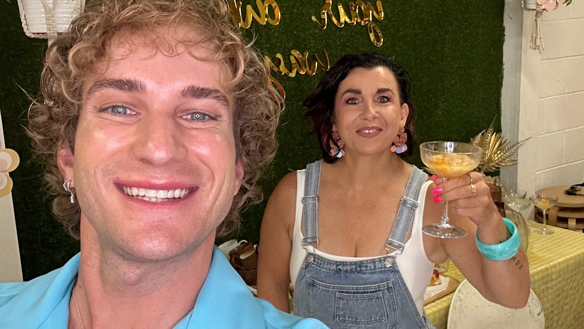 Joyful picture of a stylish man and woman raising a cocktail glass with a artistic background