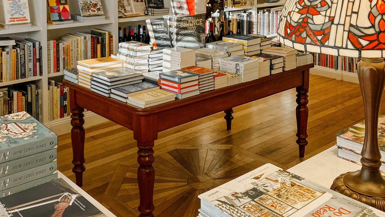 A central table of beautifully stacked books beneath warm light.