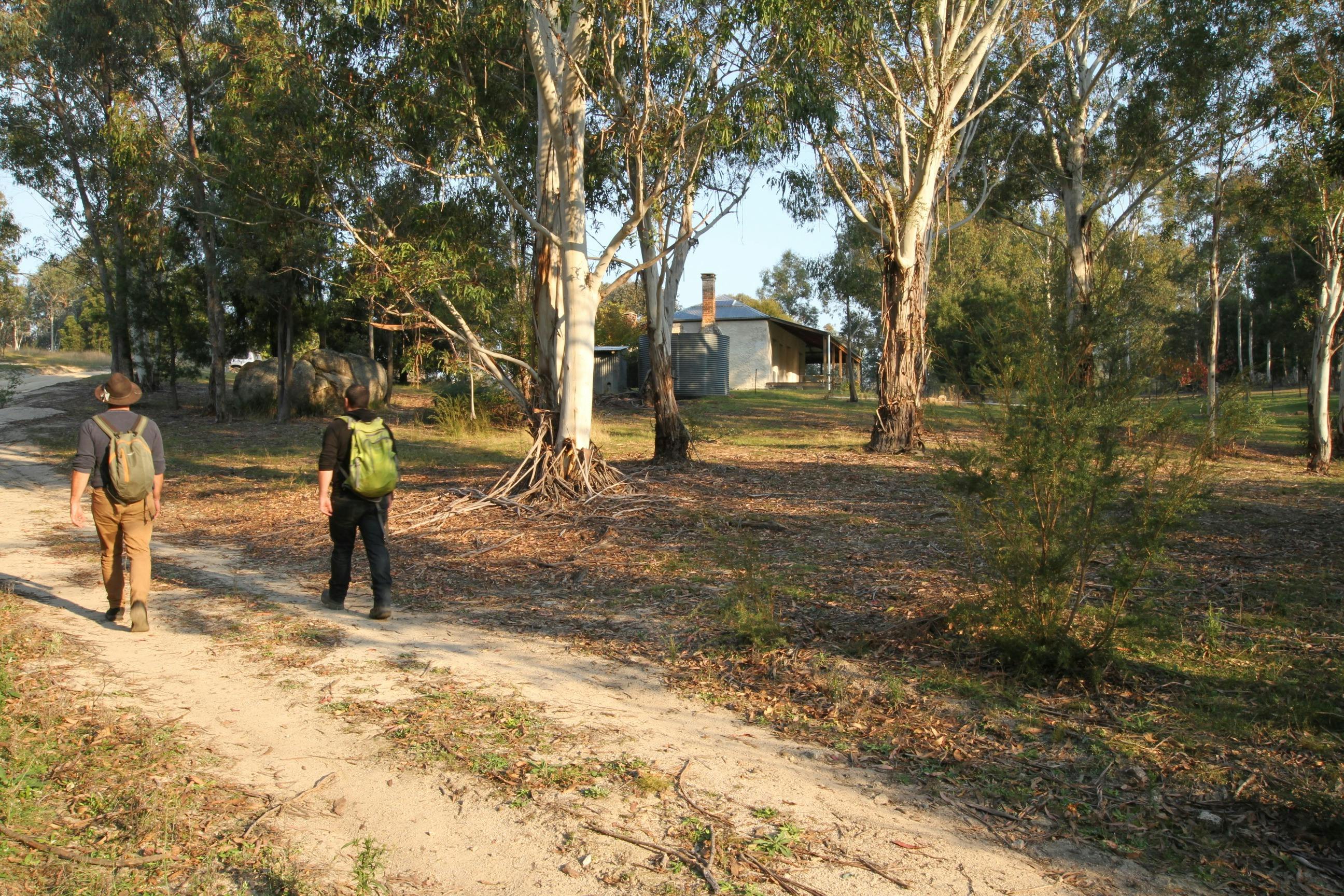 2 people walking on track in Australian bush to heritage property