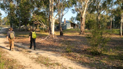 2 people walking on track in Australian bush to heritage property