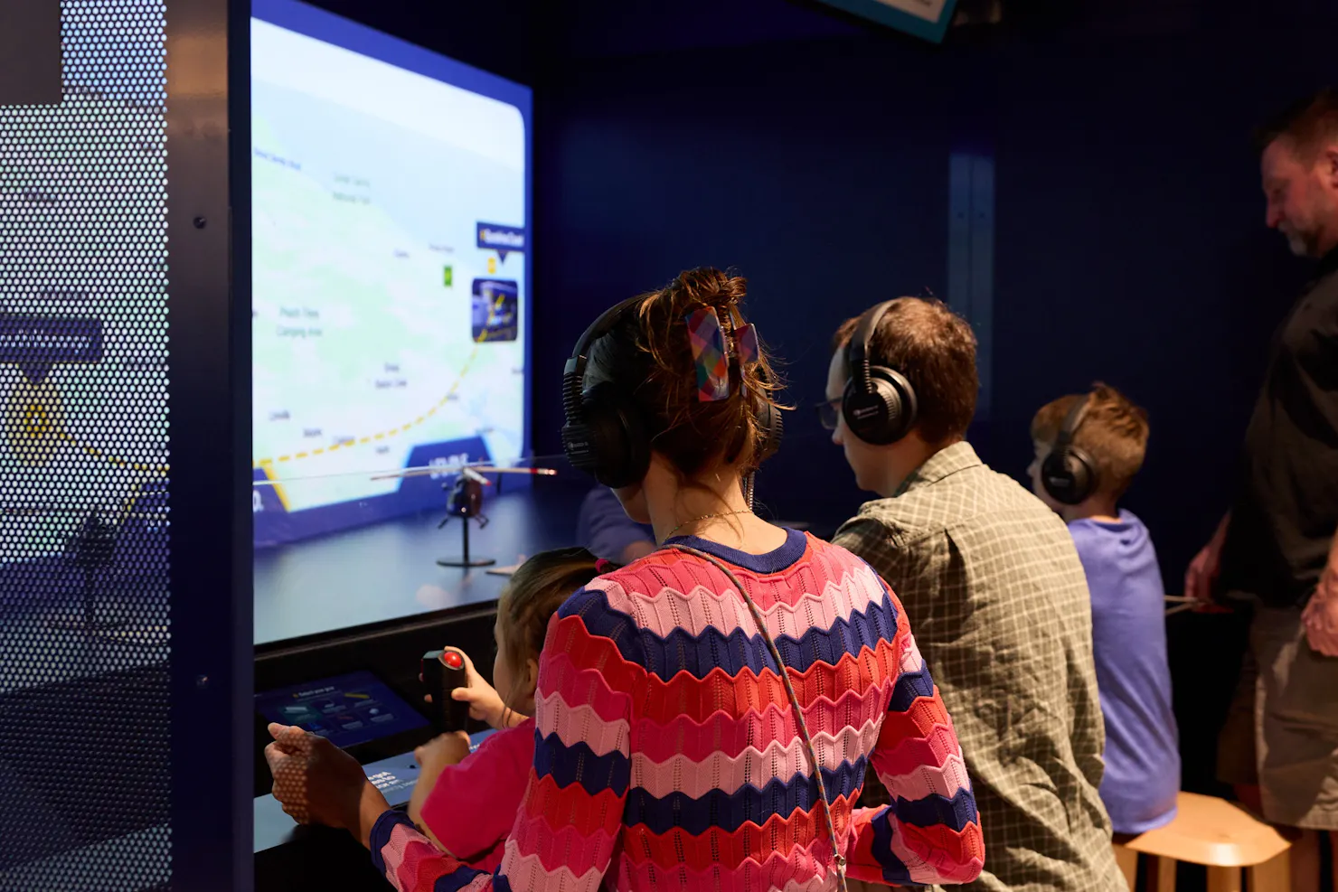 Family using joystick to fly a helicopter