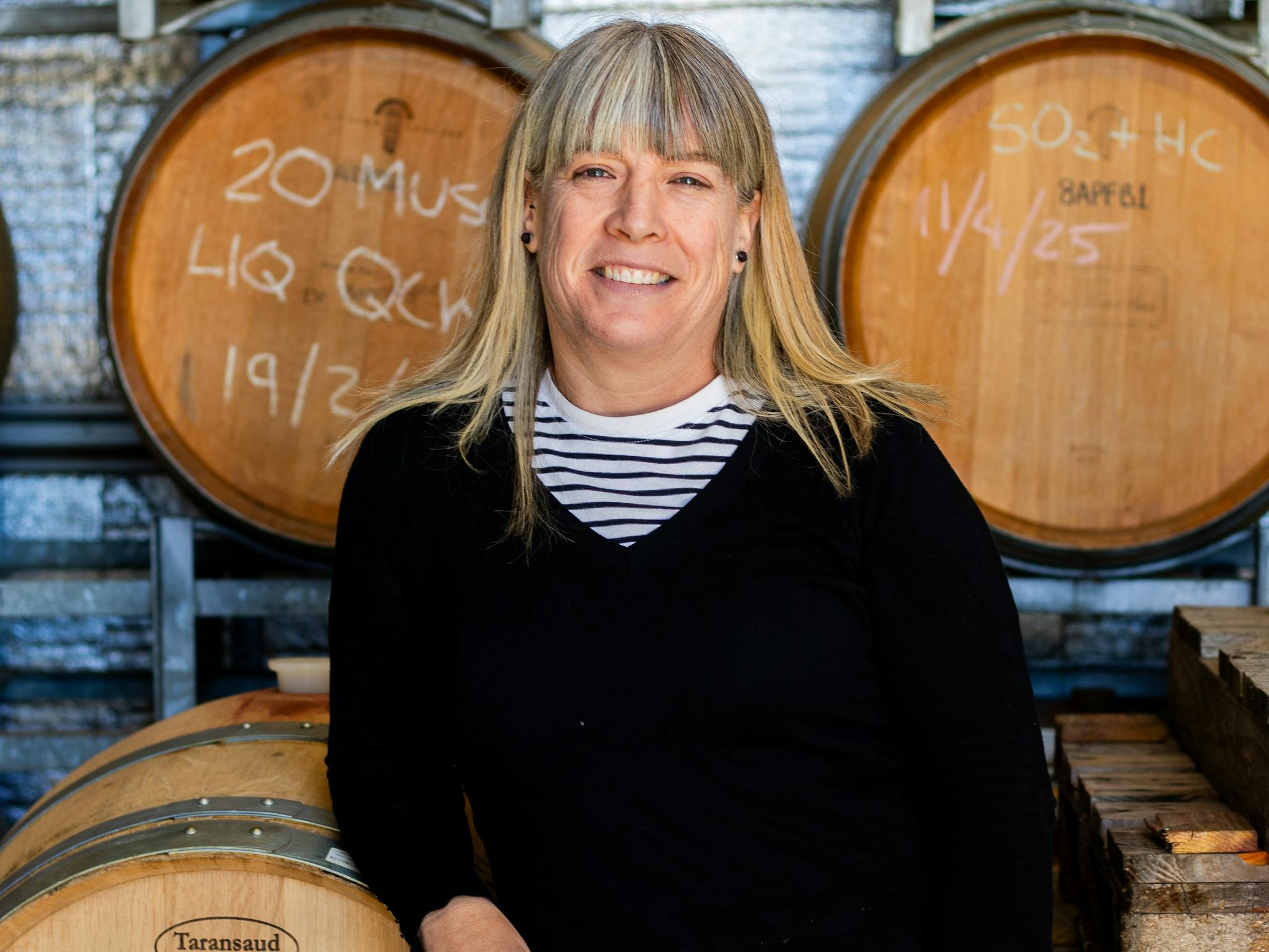 Winemaker leaning on wine barrels Winemaker leaning on wine barrels