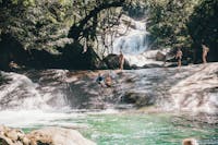 Two guest slide down the natural rock water slide at Josephine Falls in Tropical North Queensland
