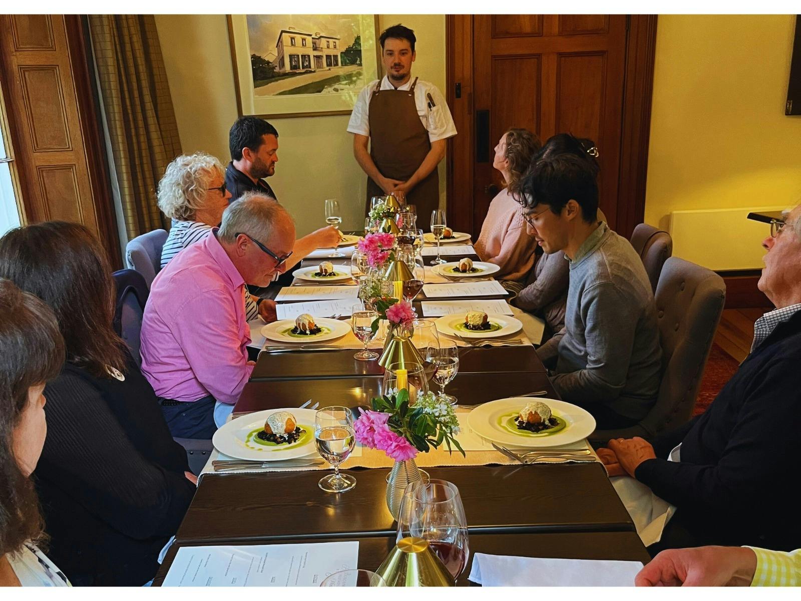 A group of Dining guests seated in the main dining room with their meals