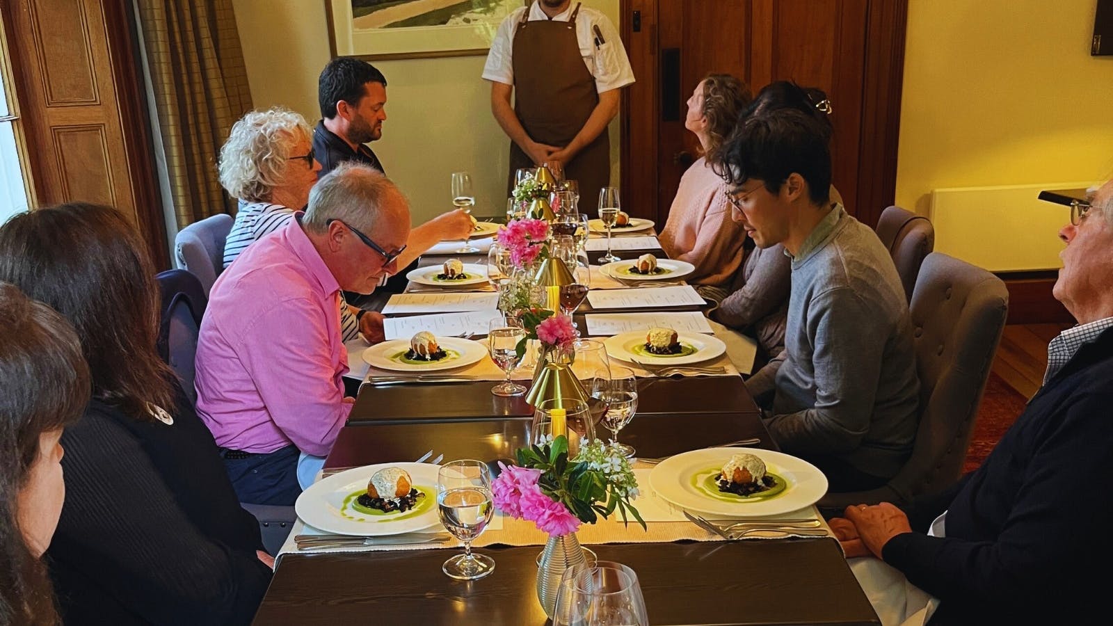 A group of Dining guests seated in the main dining room with their meals