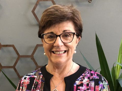 Headshot of woman with short brown hair wearing glasses