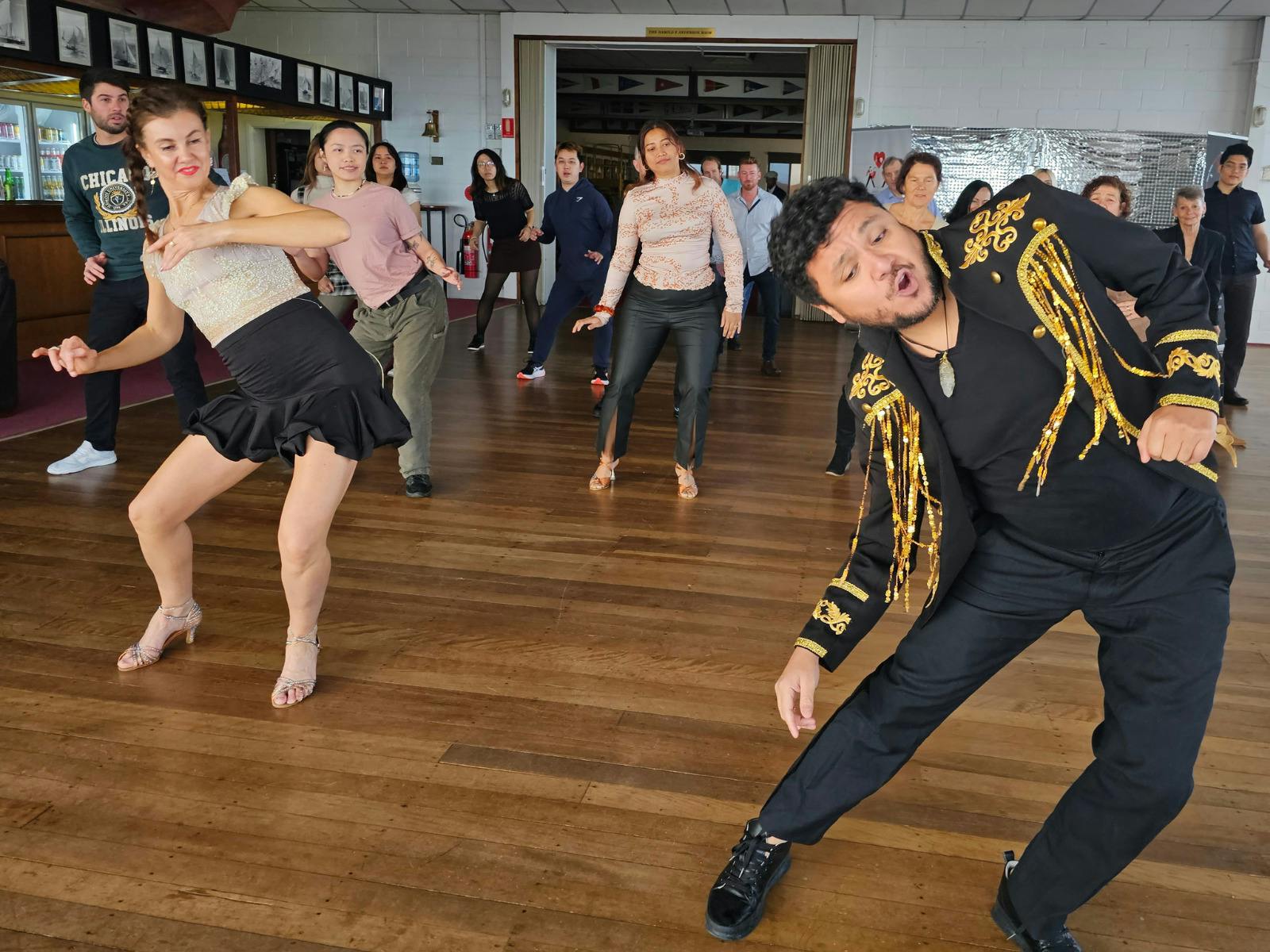 Dance Instructor showing dancers a side roll to warm them up and get the dance party going