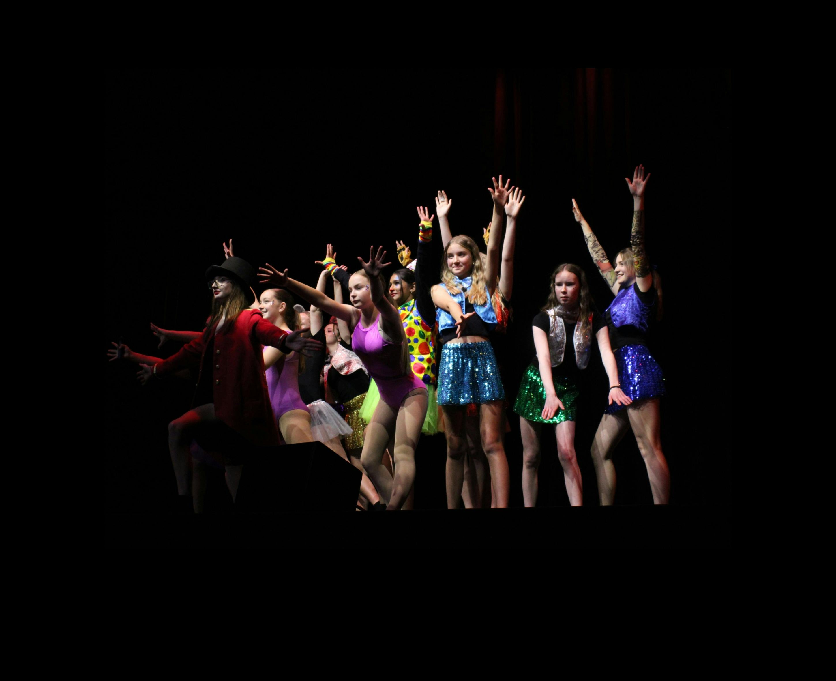 Students on stage in colourful costumes