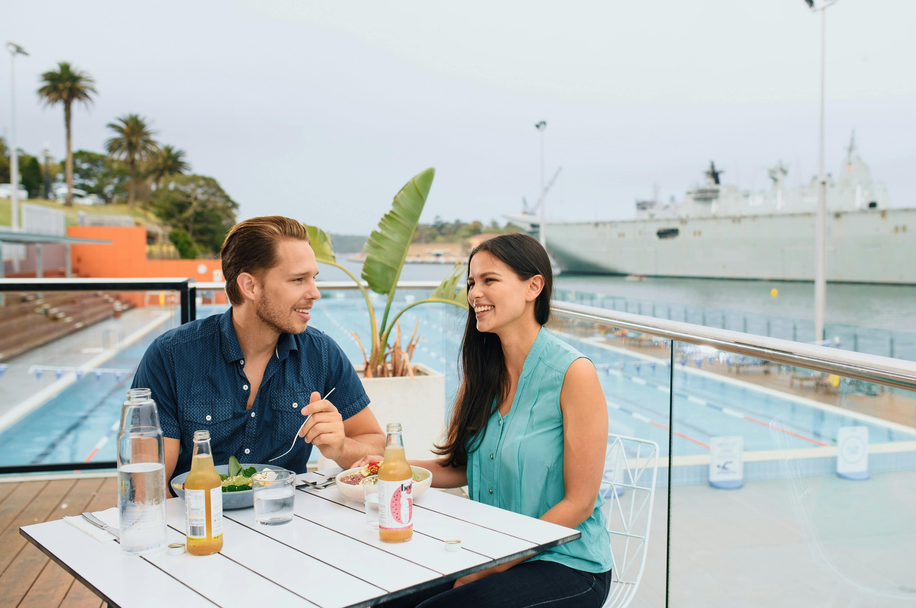 Couple enjoying food and drink at Andrew Boy Charlton Pool, Sydney