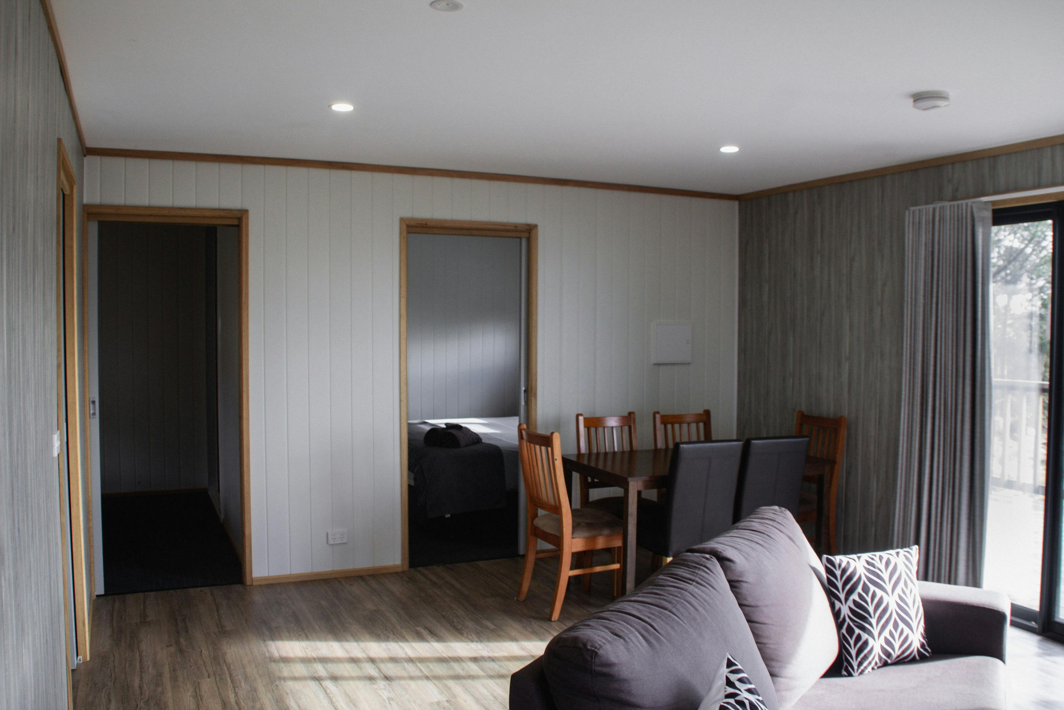 Comfortable open-plan living and dining area with seating, dining table and views through the window