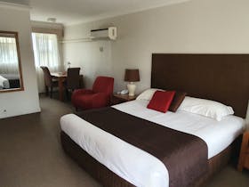 King size bed with table and chairs in rear of room