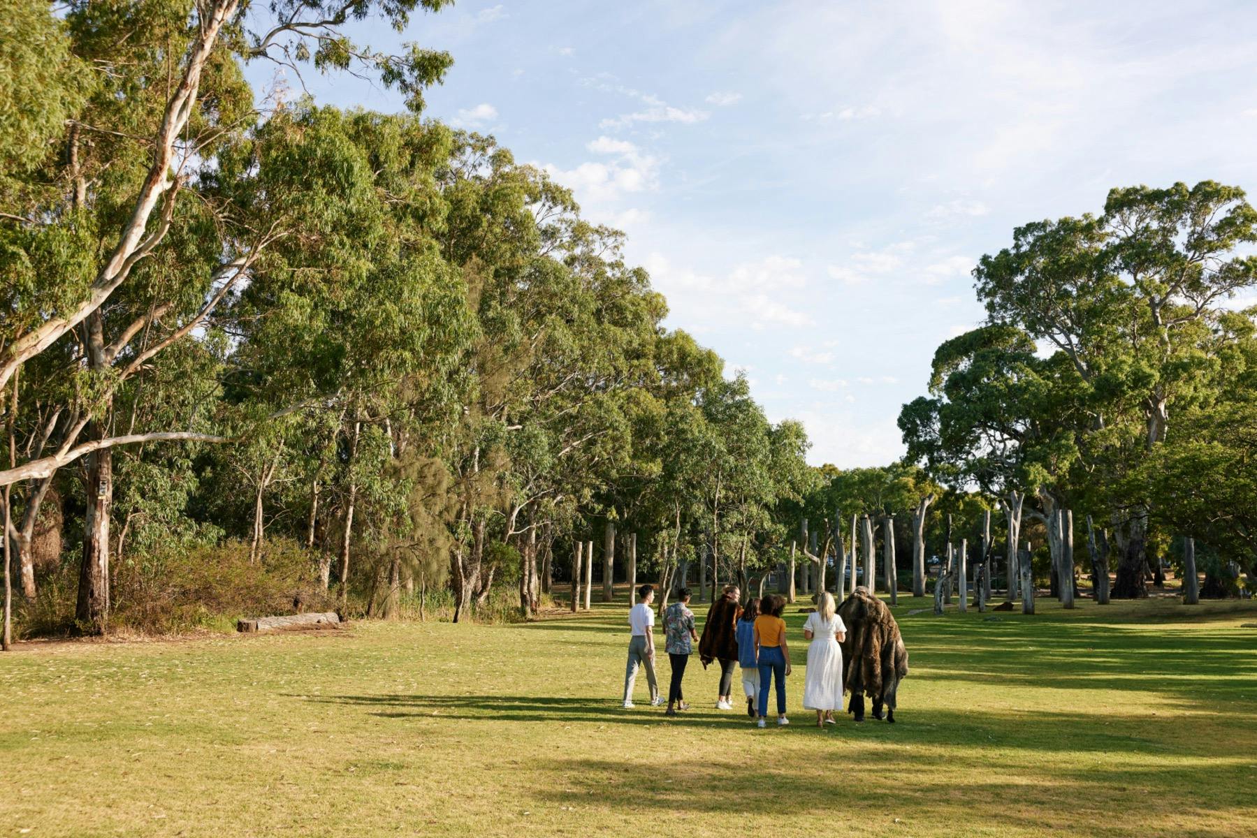 A group walking on the lawns of the Warriparinga Wetlands