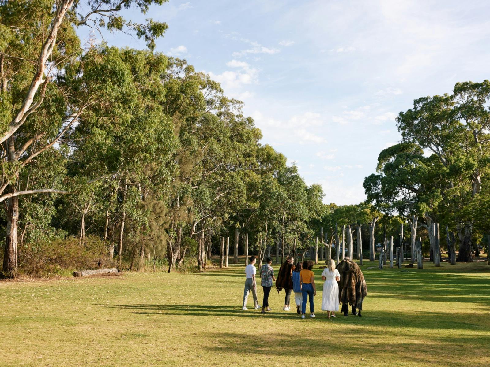 A group walking on the lawns of the Warriparinga Wetlands