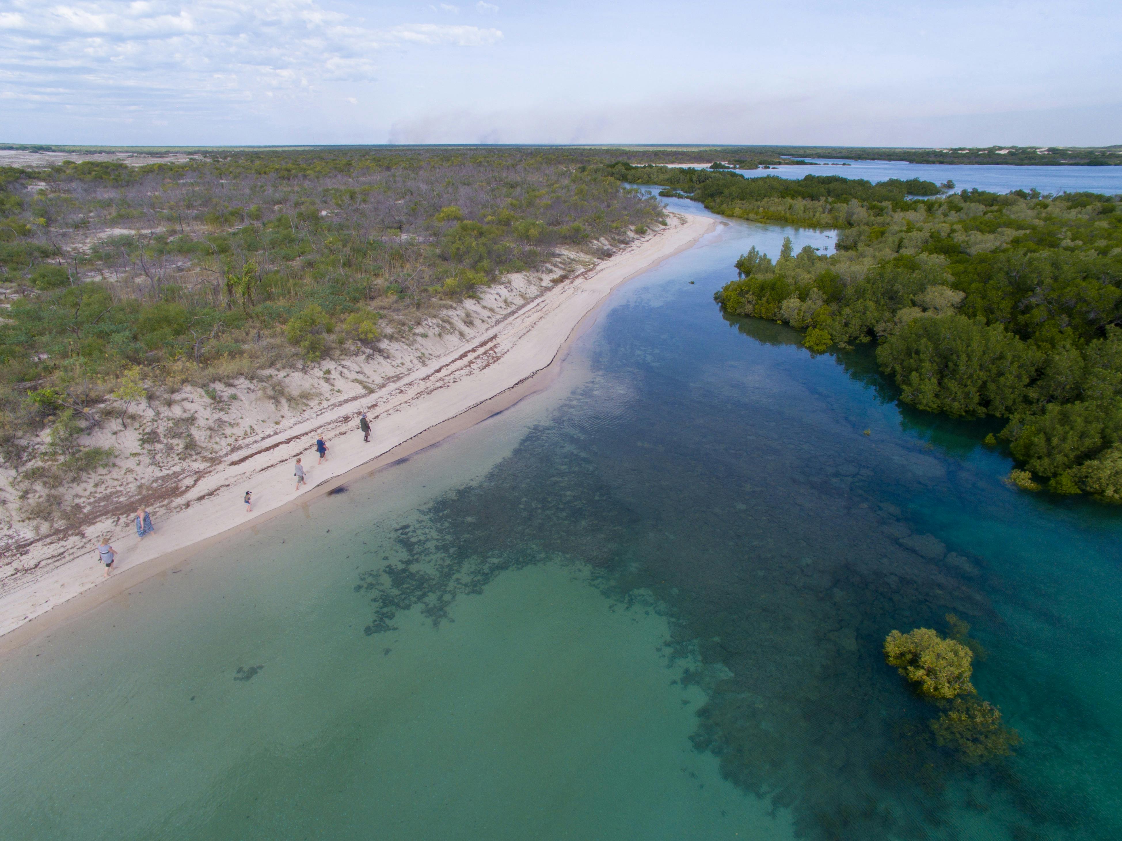 Aerial shot of the beach with bright blue waters.