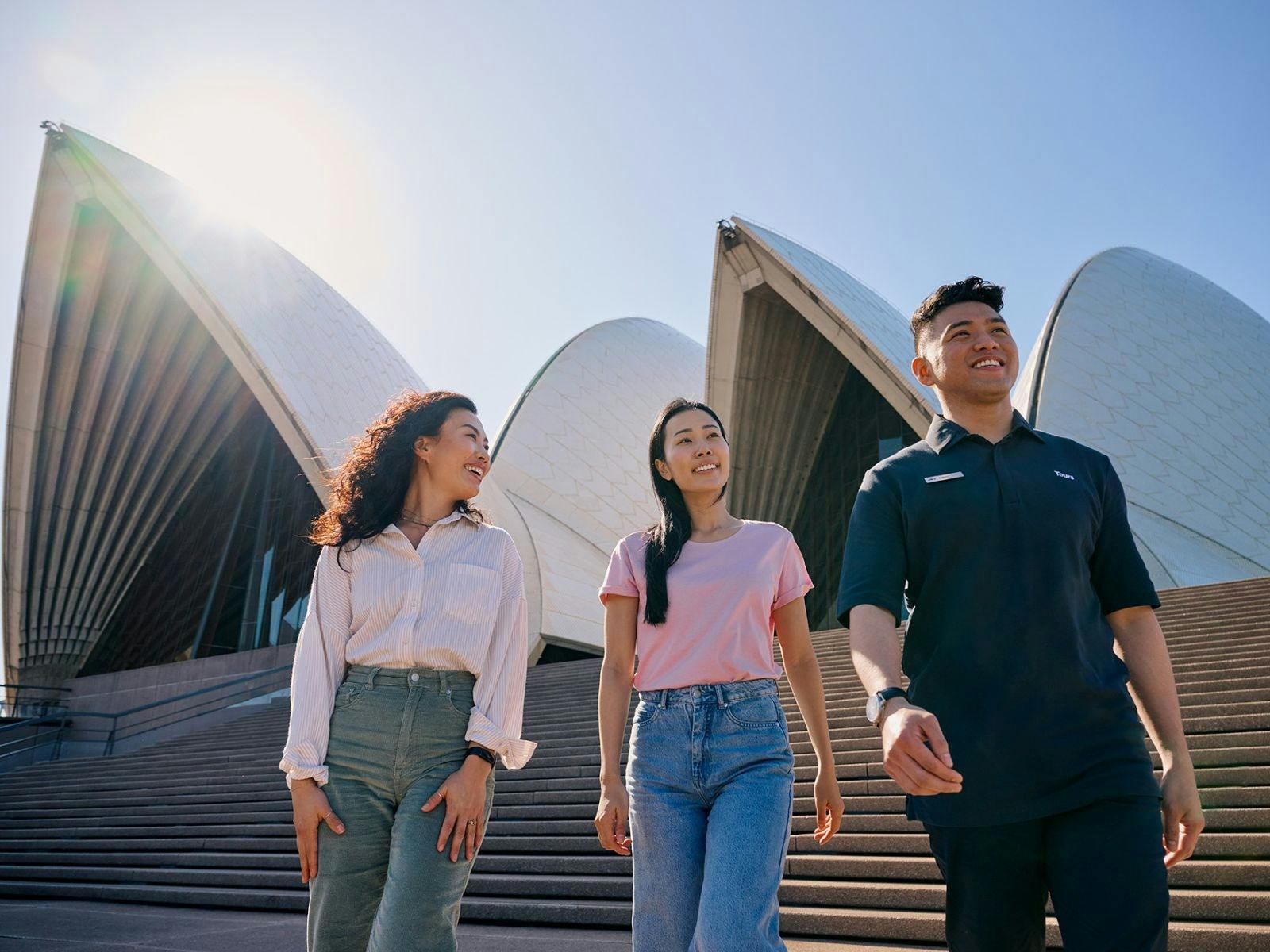 Two women and a tour guide walking down the  steps of the Opera House