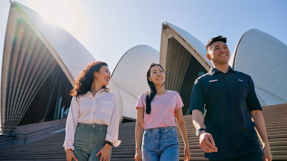 Two women and a tour guide walking down the steps of the Opera House Two women and a tour guide walking down the steps of the Opera House