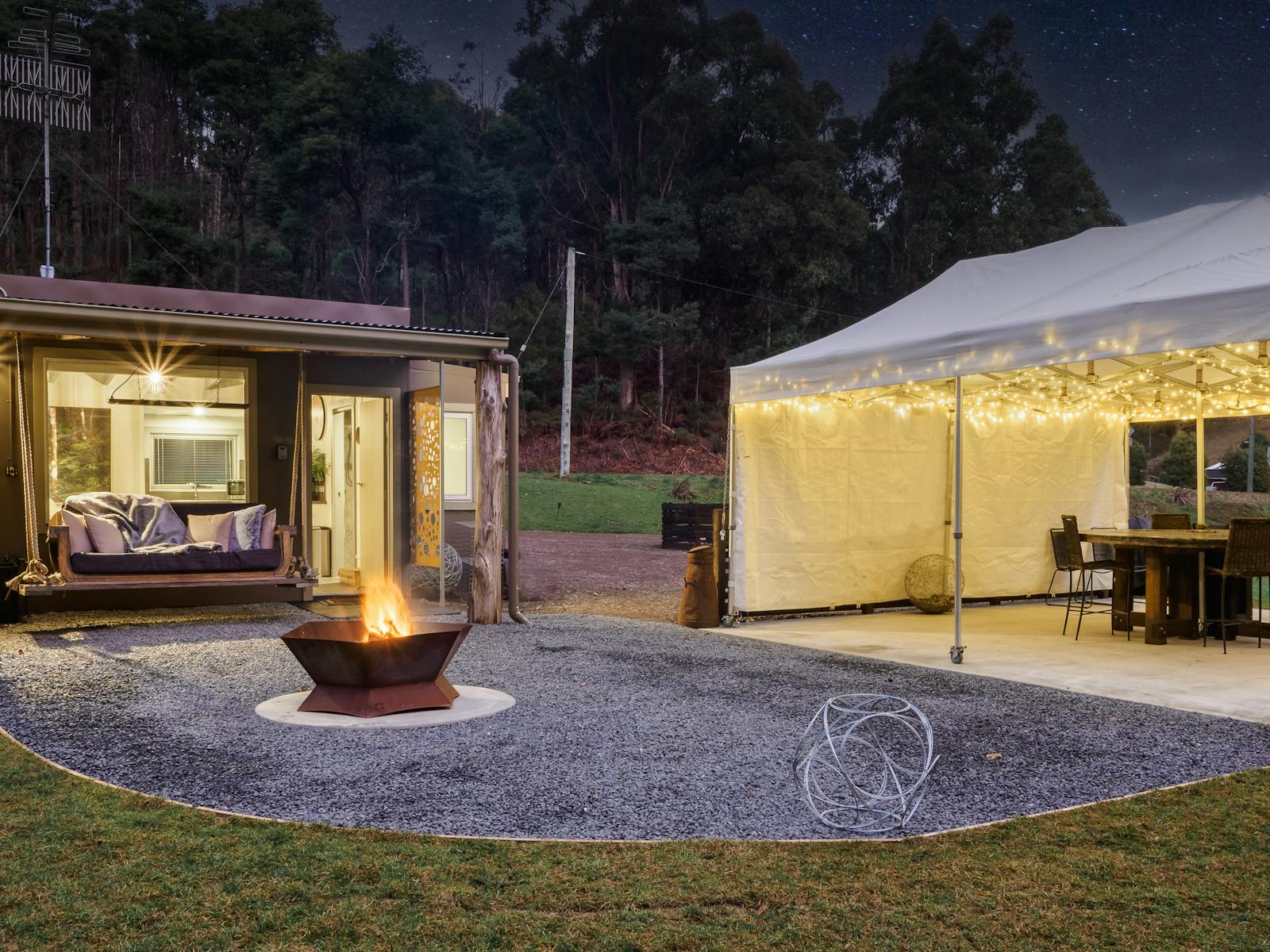 Fire pit, bespoke swinging couch with above heating, level area large marquee with 800 fairy lights