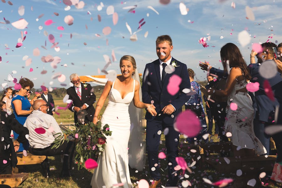 Married couple walking through confetti