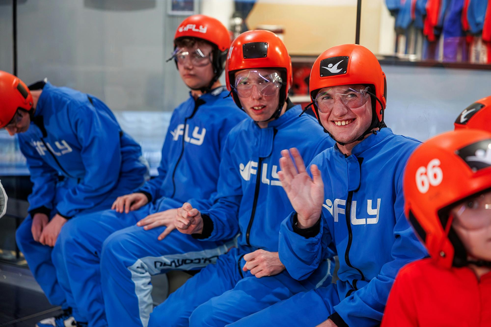 flyers waiting to fly while one waves and smiles at the camera.