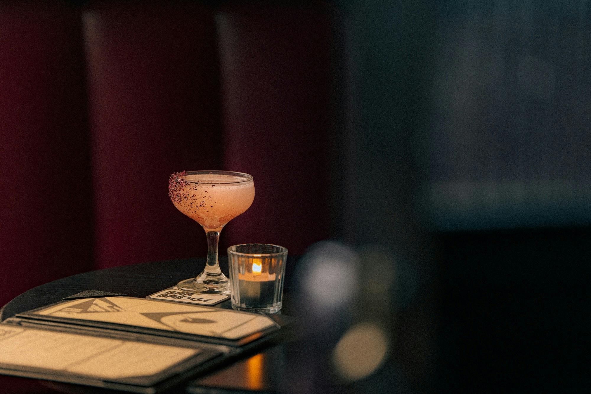A pink Margarita-style Sour in a coupe glass on a table