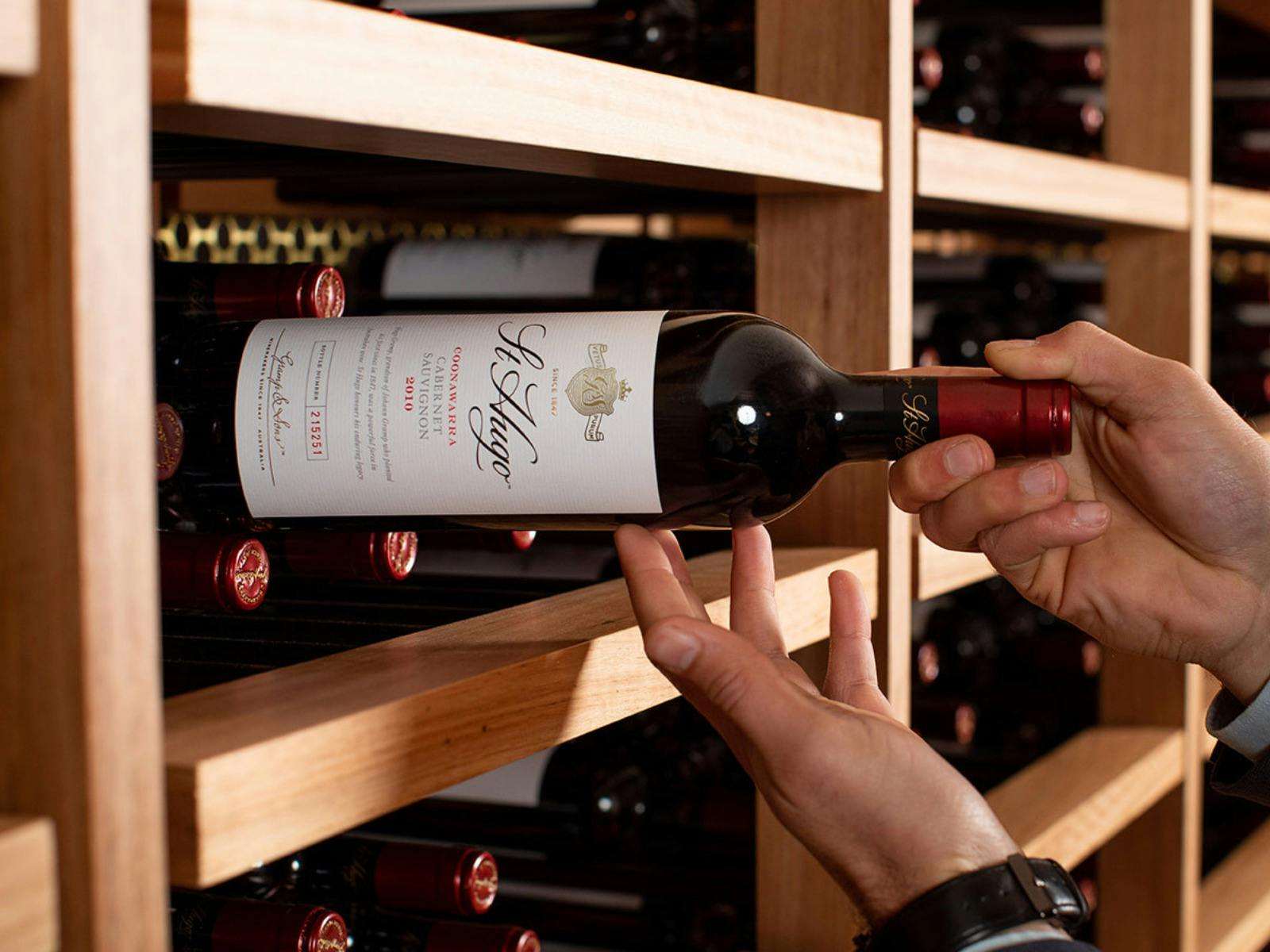St Hugo wine bottle being pulled off wine rack