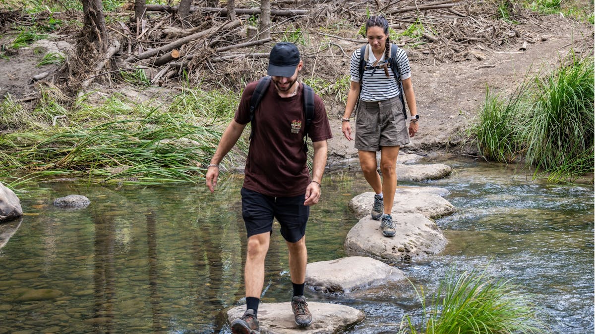 A couple walking across water on stepping stones