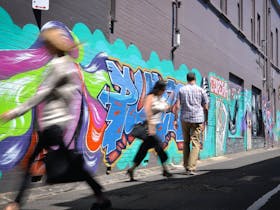 Colourful words in graffiti on black wall