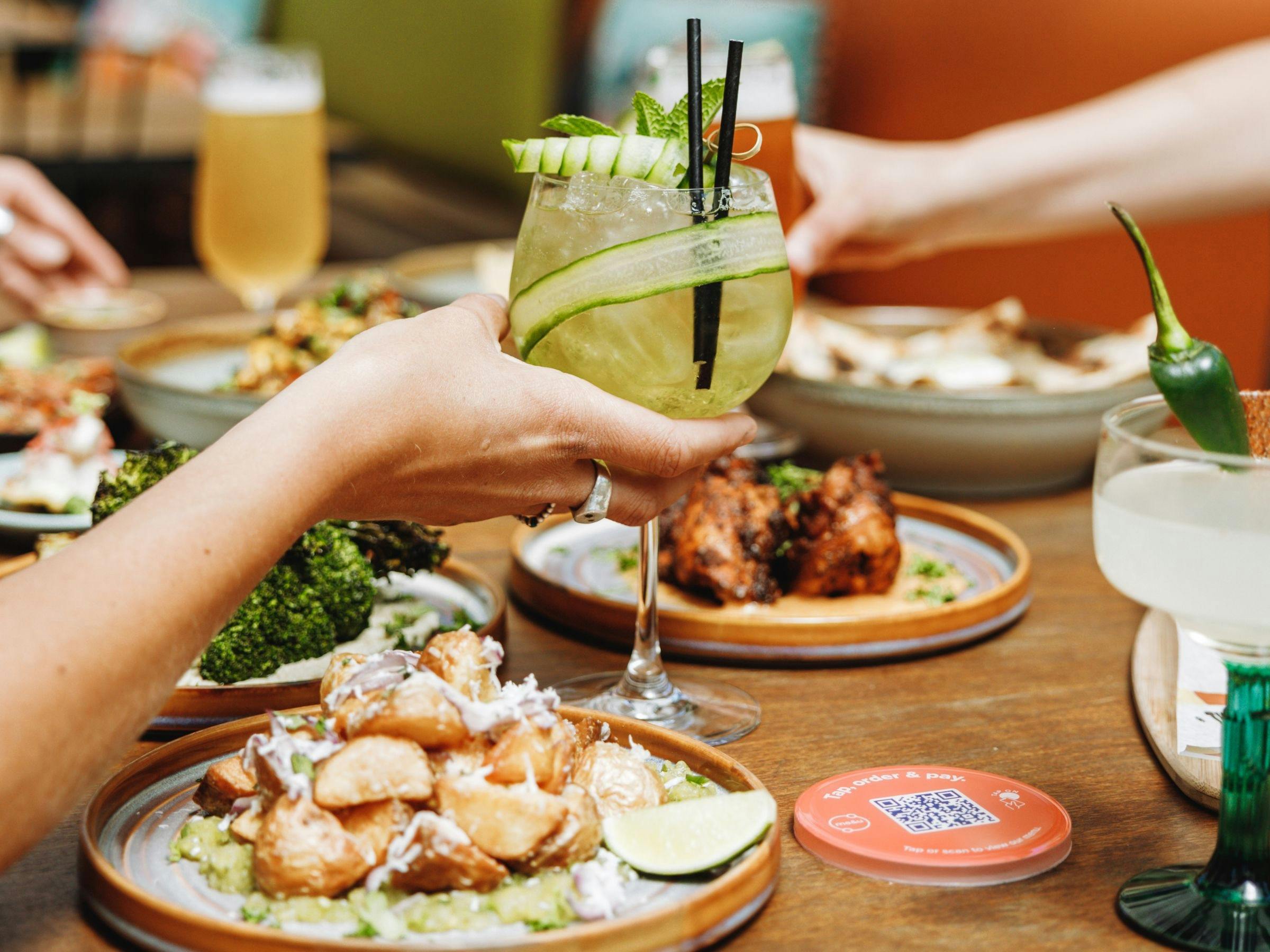 Cocktails and Southern American dishes on a table at The Yard Bright