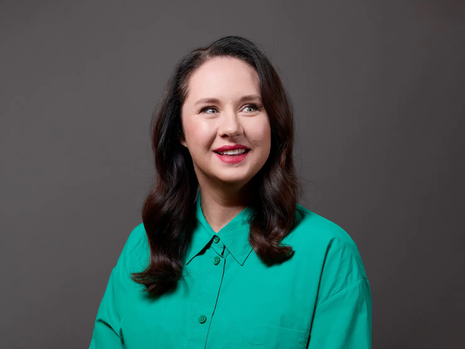 Brunette woman in a green shirt smiles