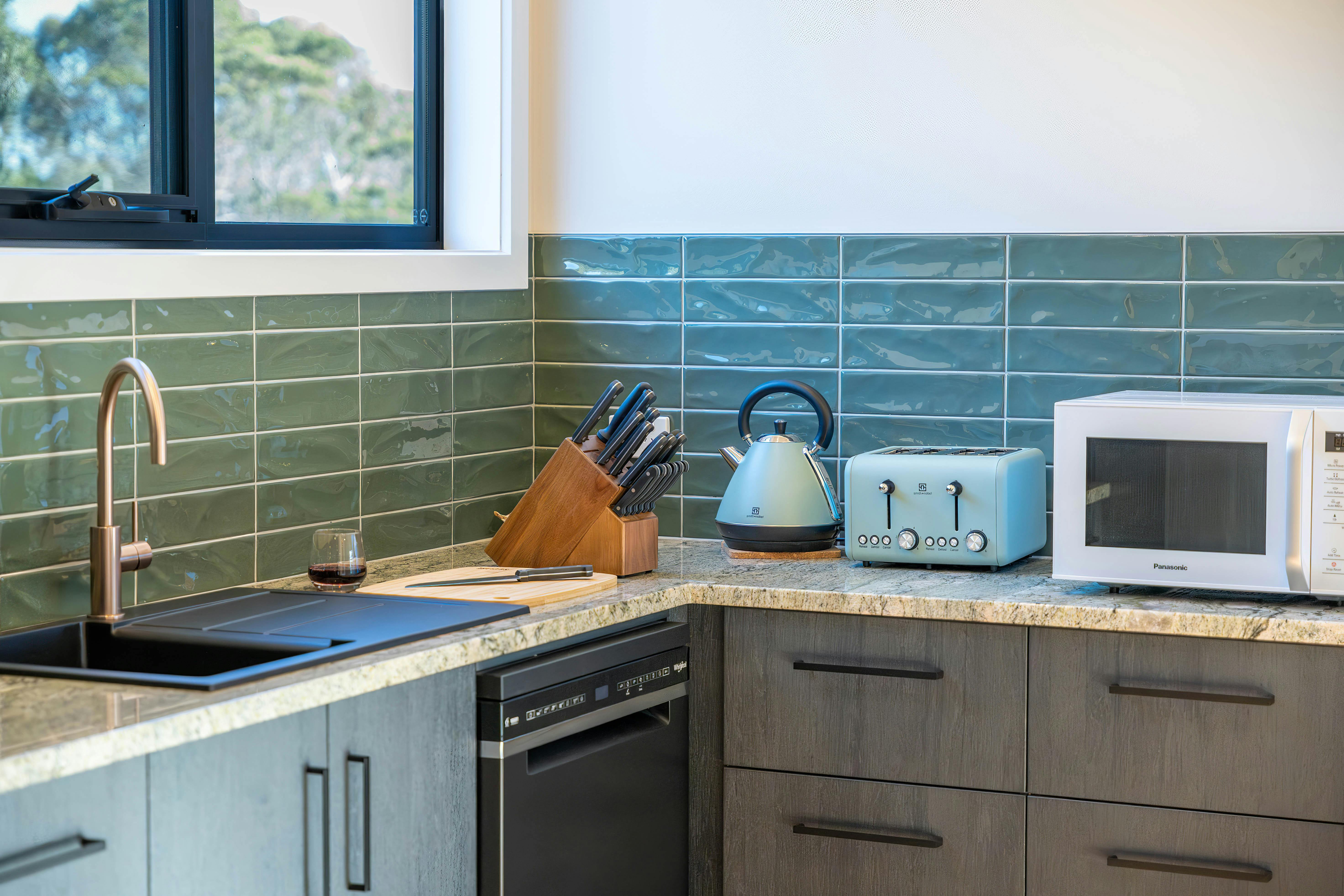 Kitchen area with sink, kettle, toaster, microwave, kitchen knives