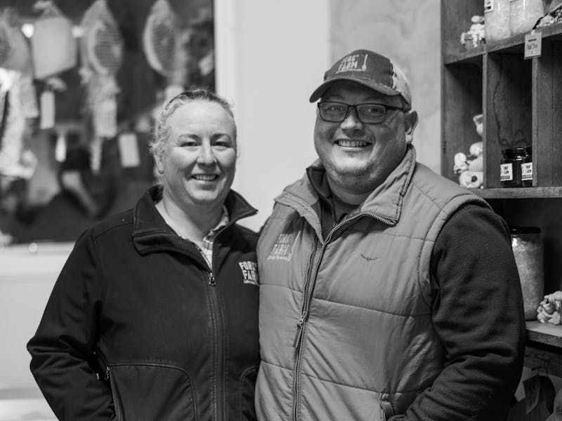 Black-and-white photo of Fork it Farm's owners Daniel and Kim smiling together.