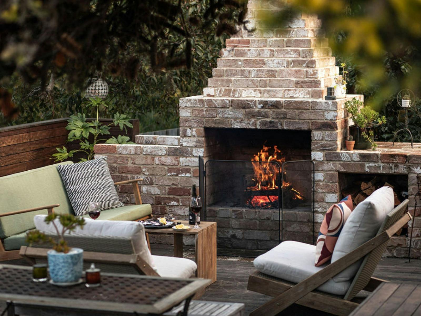 Outdoor Fire - Open flame fire in brick fireplace on backyard deck.