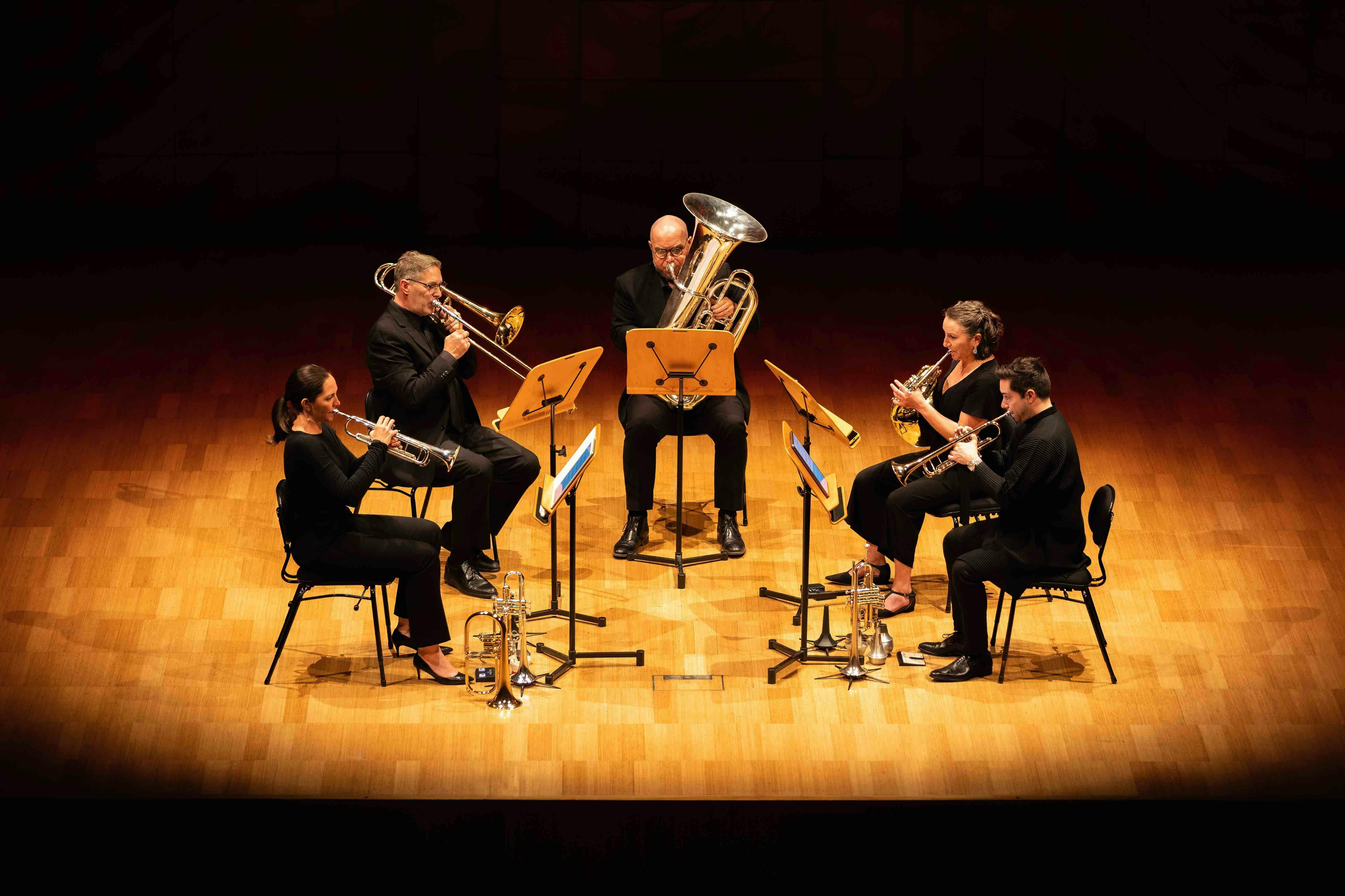 Five brass players performing