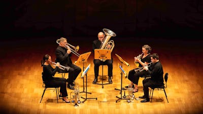 Five brass players performing