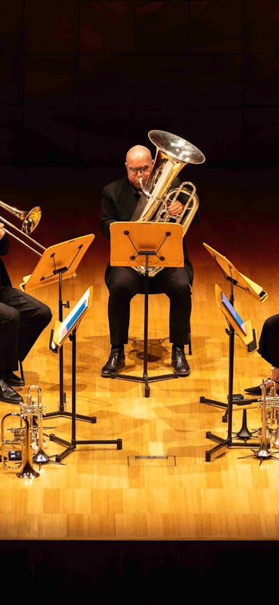 Five brass players performing