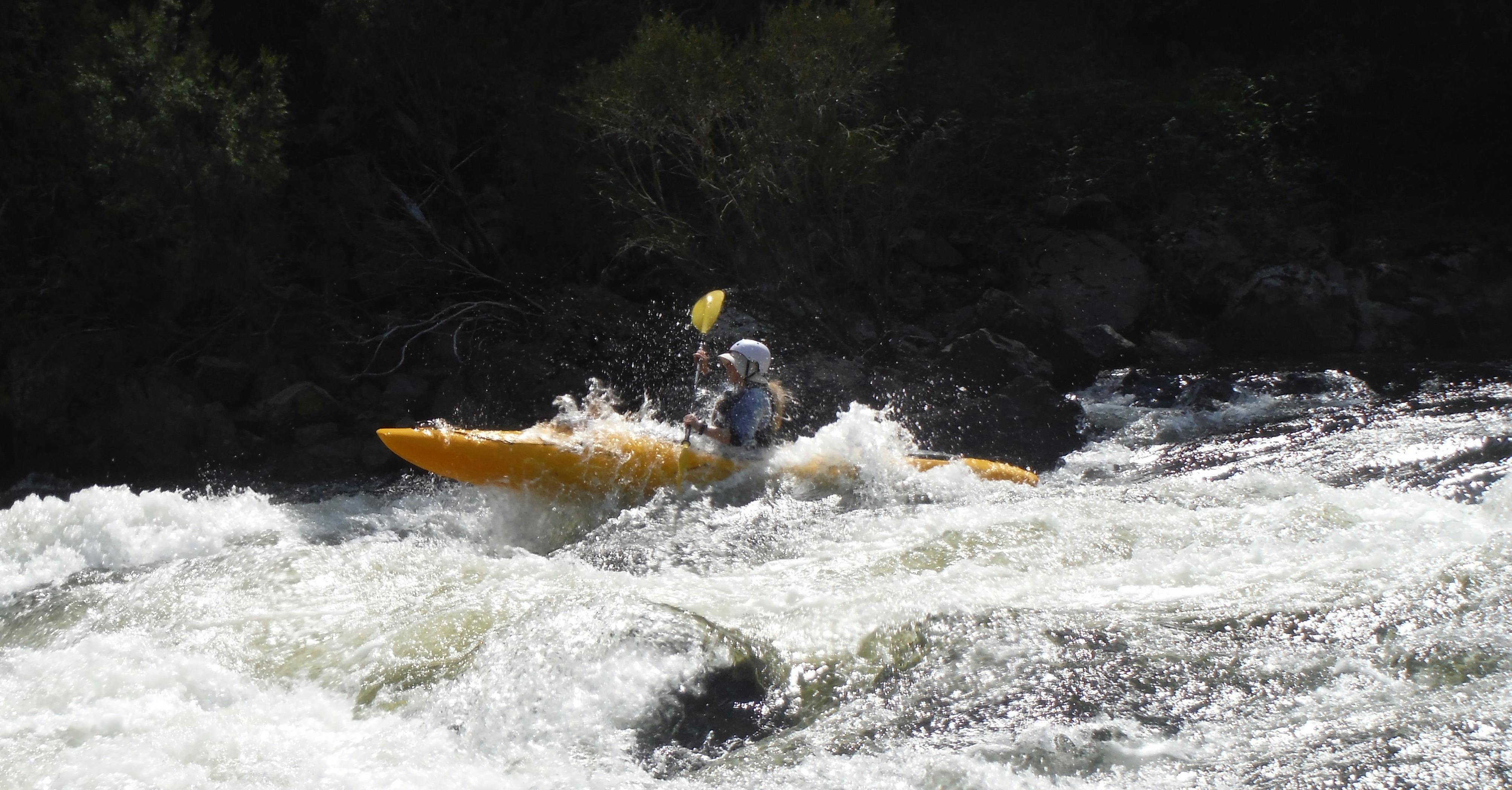 A kayak is launching itself out of the water on top of a wave in one of the many rapids on the Snowy