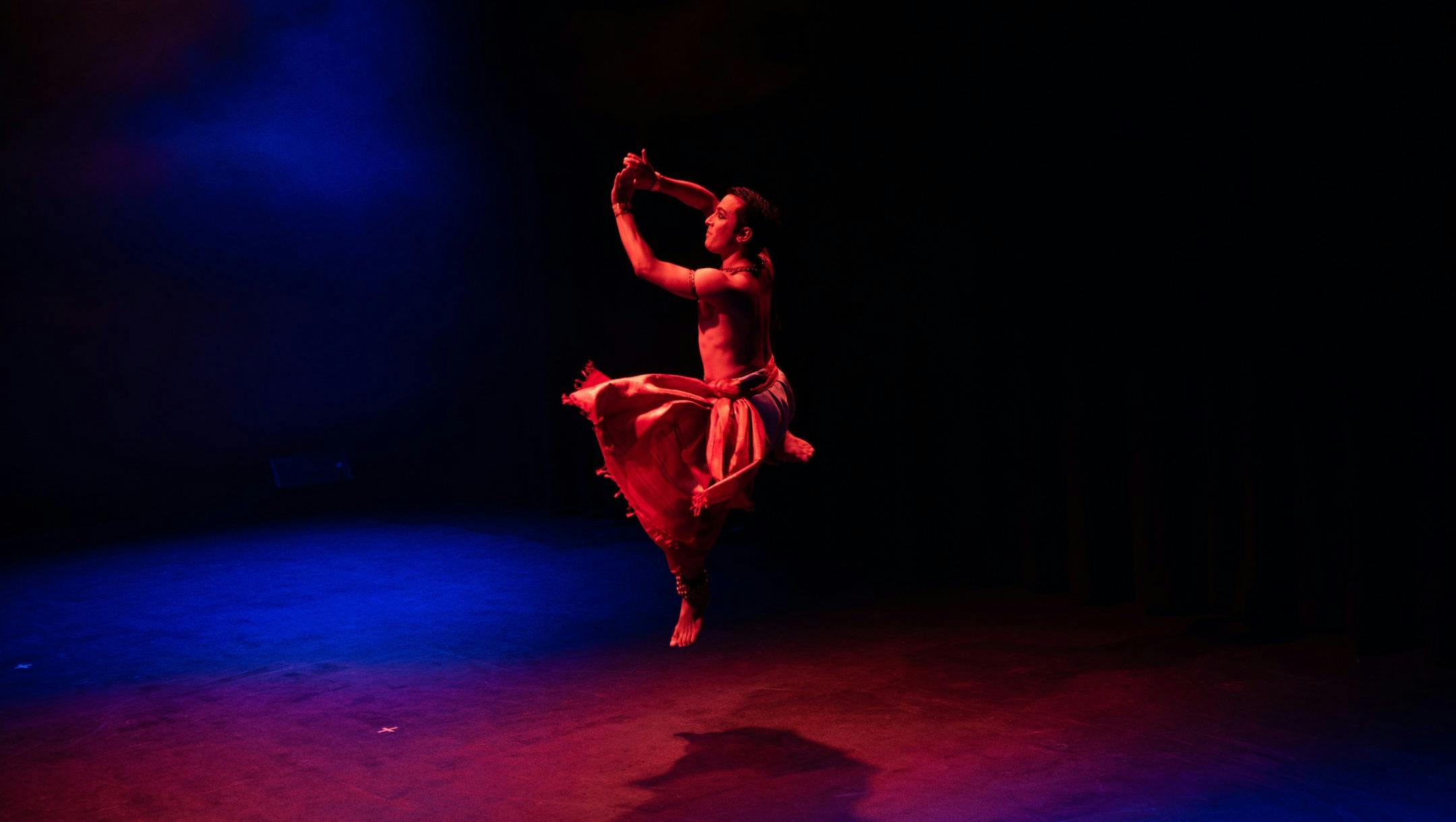 Bharathanatyam dancer Christopher Gurusamy performing on stage in Ānanda: Dance of Joy.