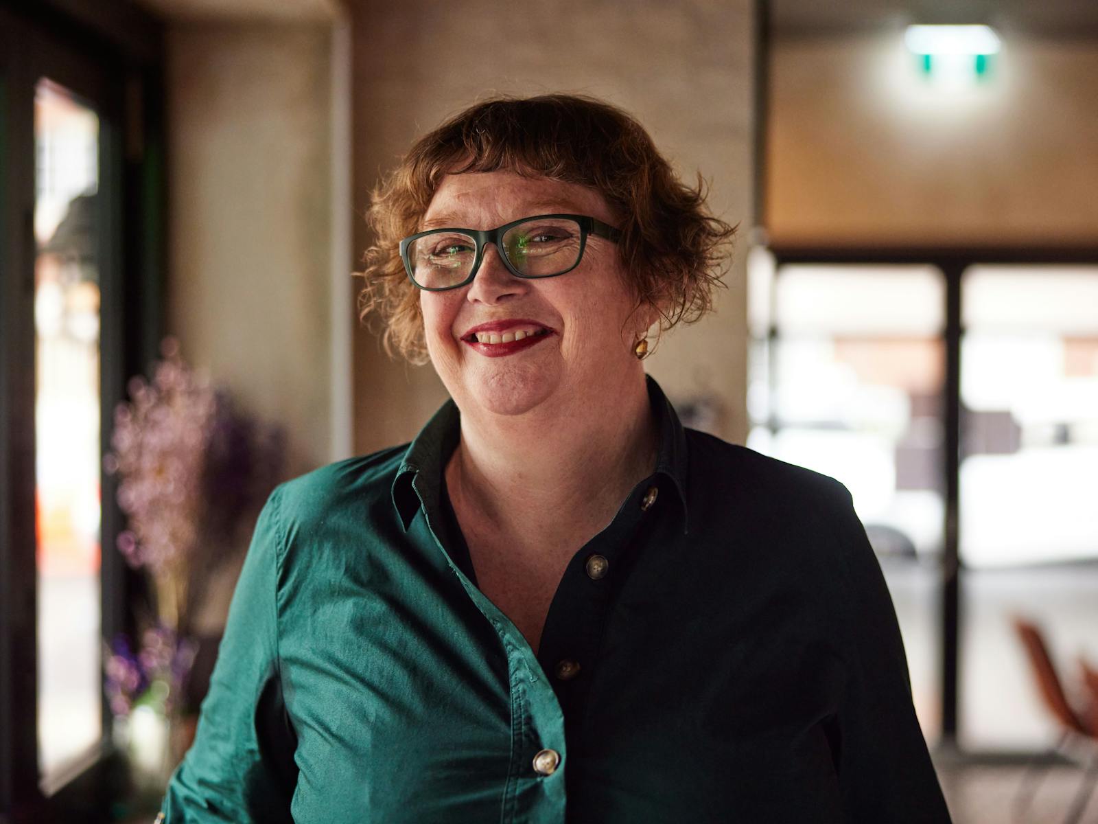 창, 녹색 드레스에 서있는 웃는 여자