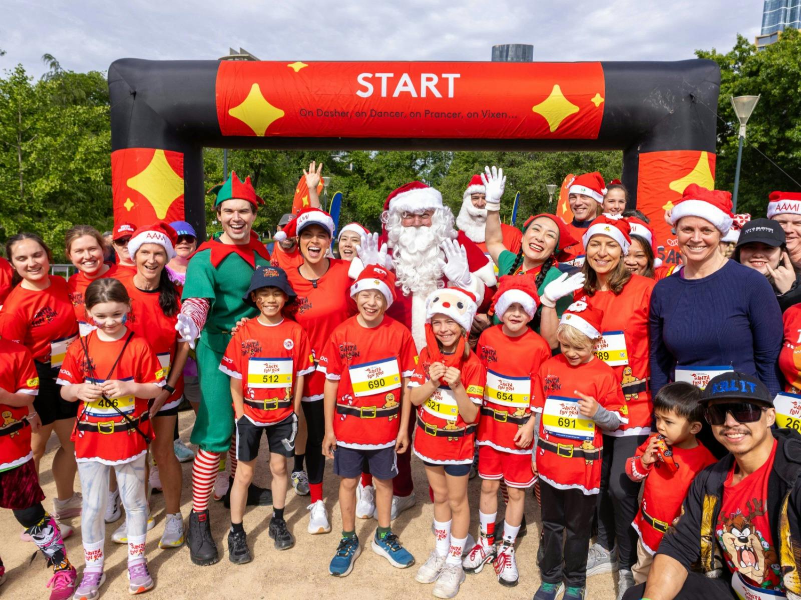 Participants smiling at the start line of Santa Fun Run