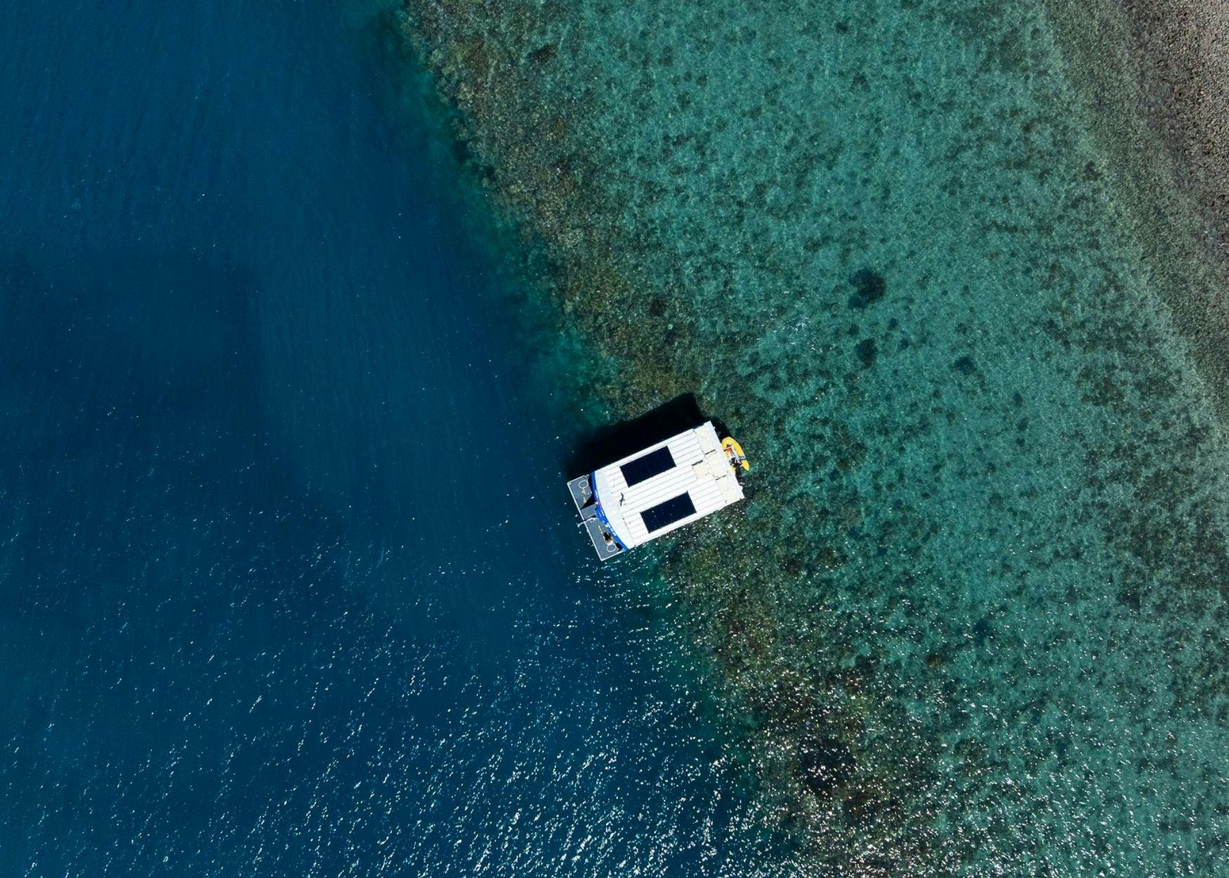 Birds eye view of glass bottom boat drifting over reef