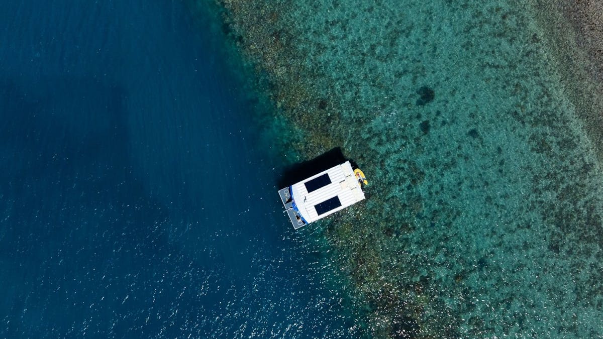 Birds eye view of glass bottom boat drifting over reef