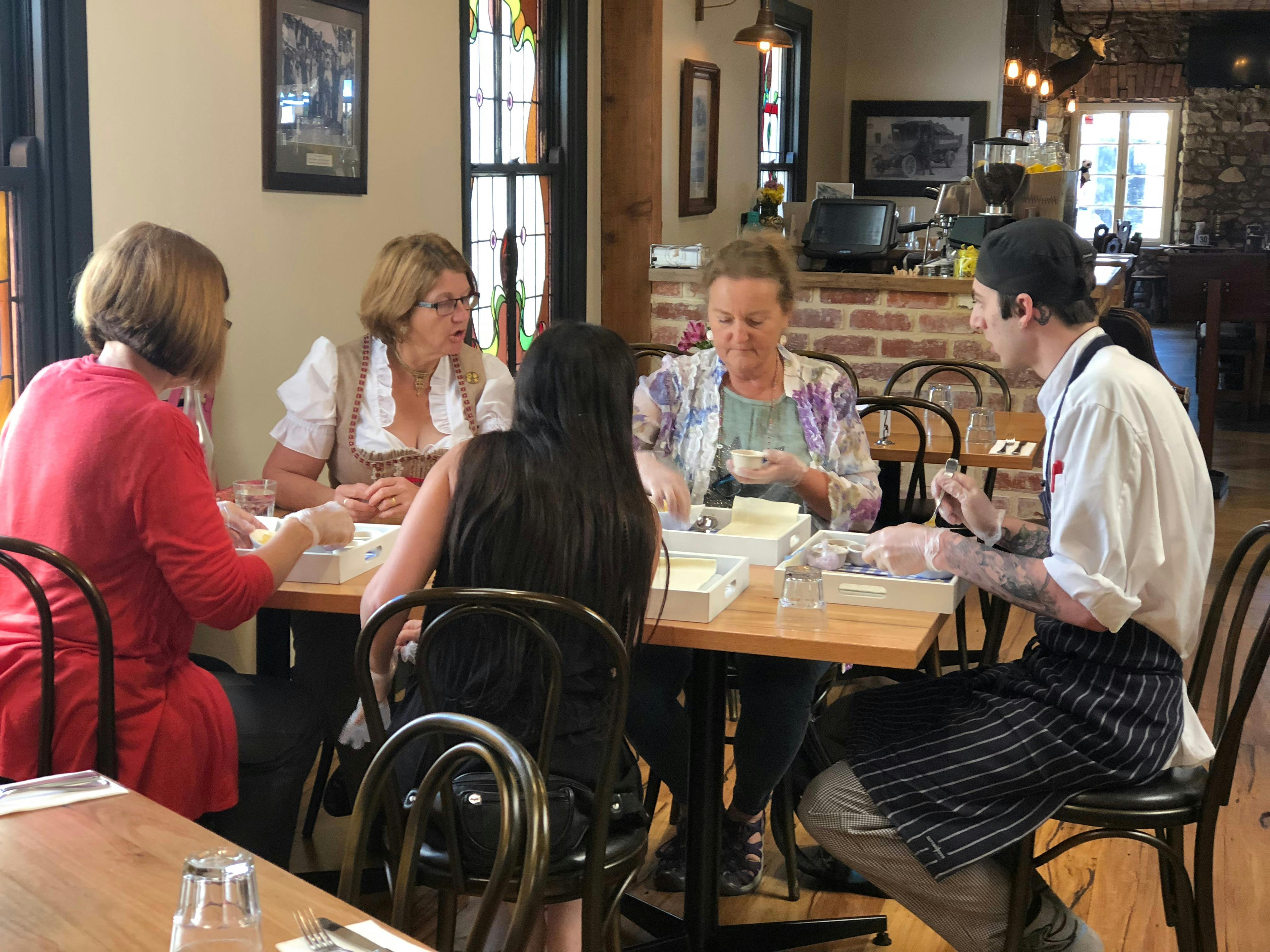 4 people being instructed in how to construct an apple strudel