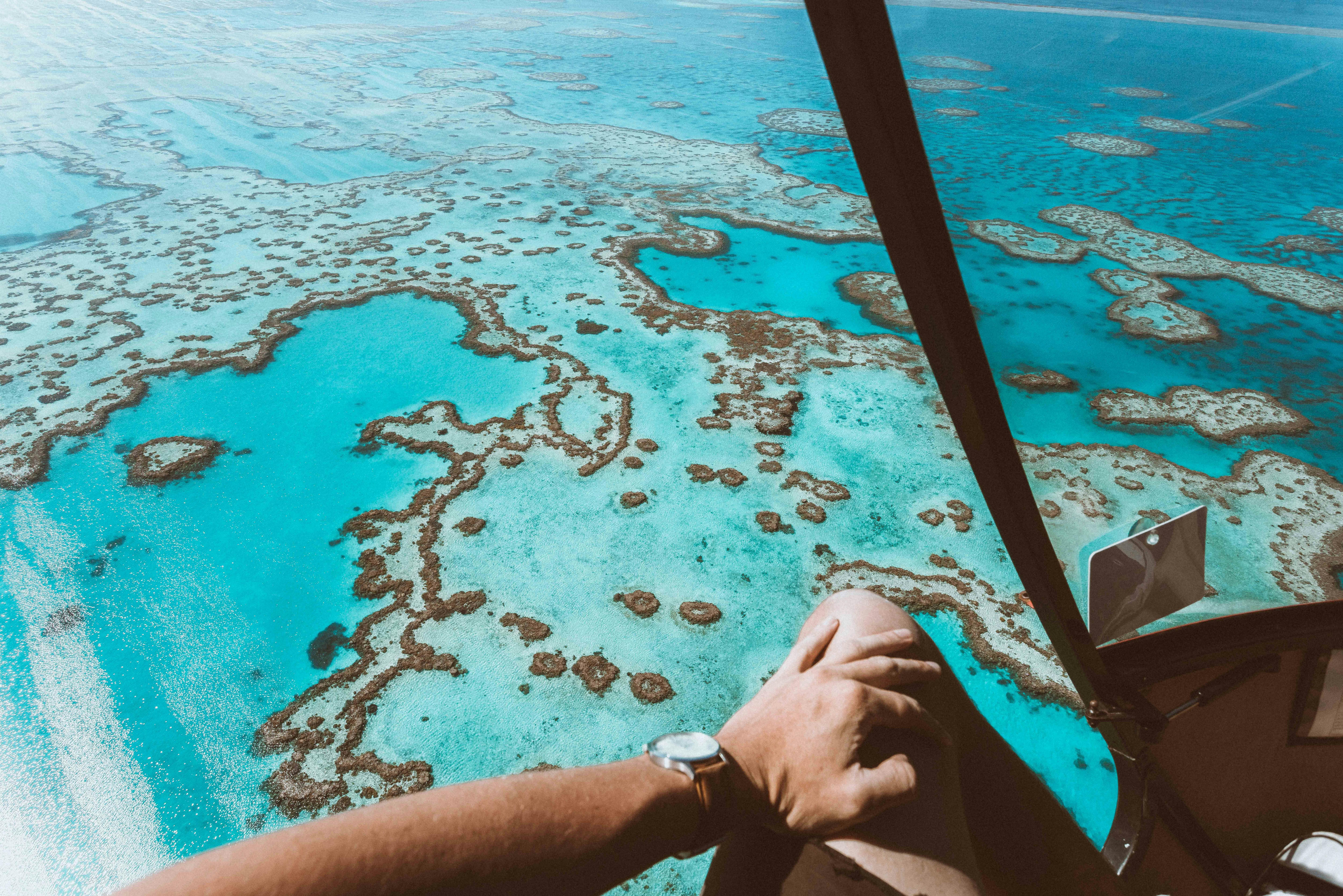 Aerial view of the calm turquoise water surrounded by coral reefs including heart shaped reef