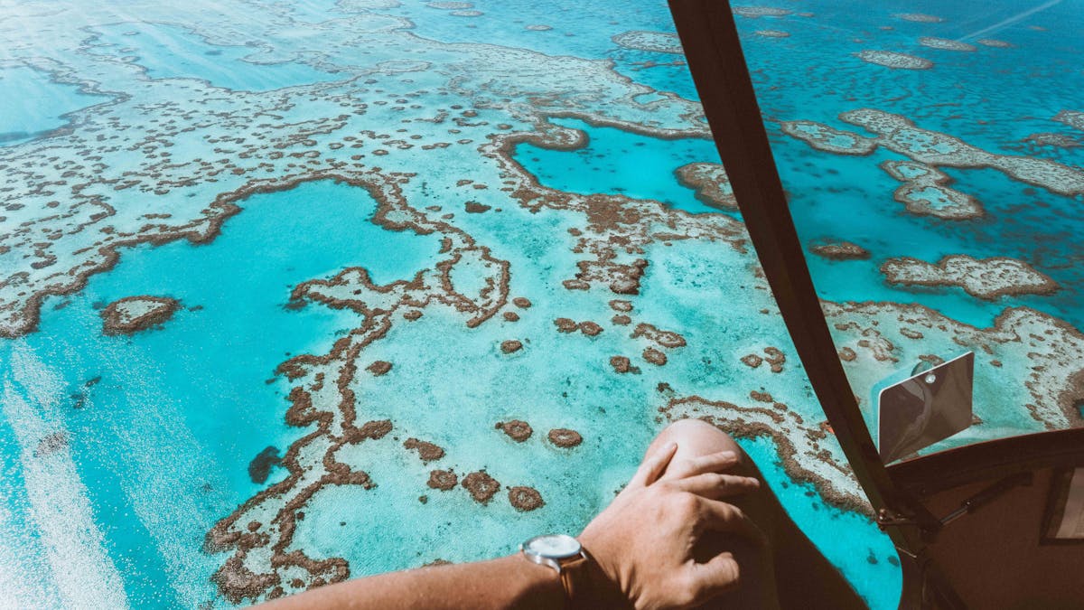 Aerial view of the calm turquoise water surrounded by coral reefs including heart shaped reef
