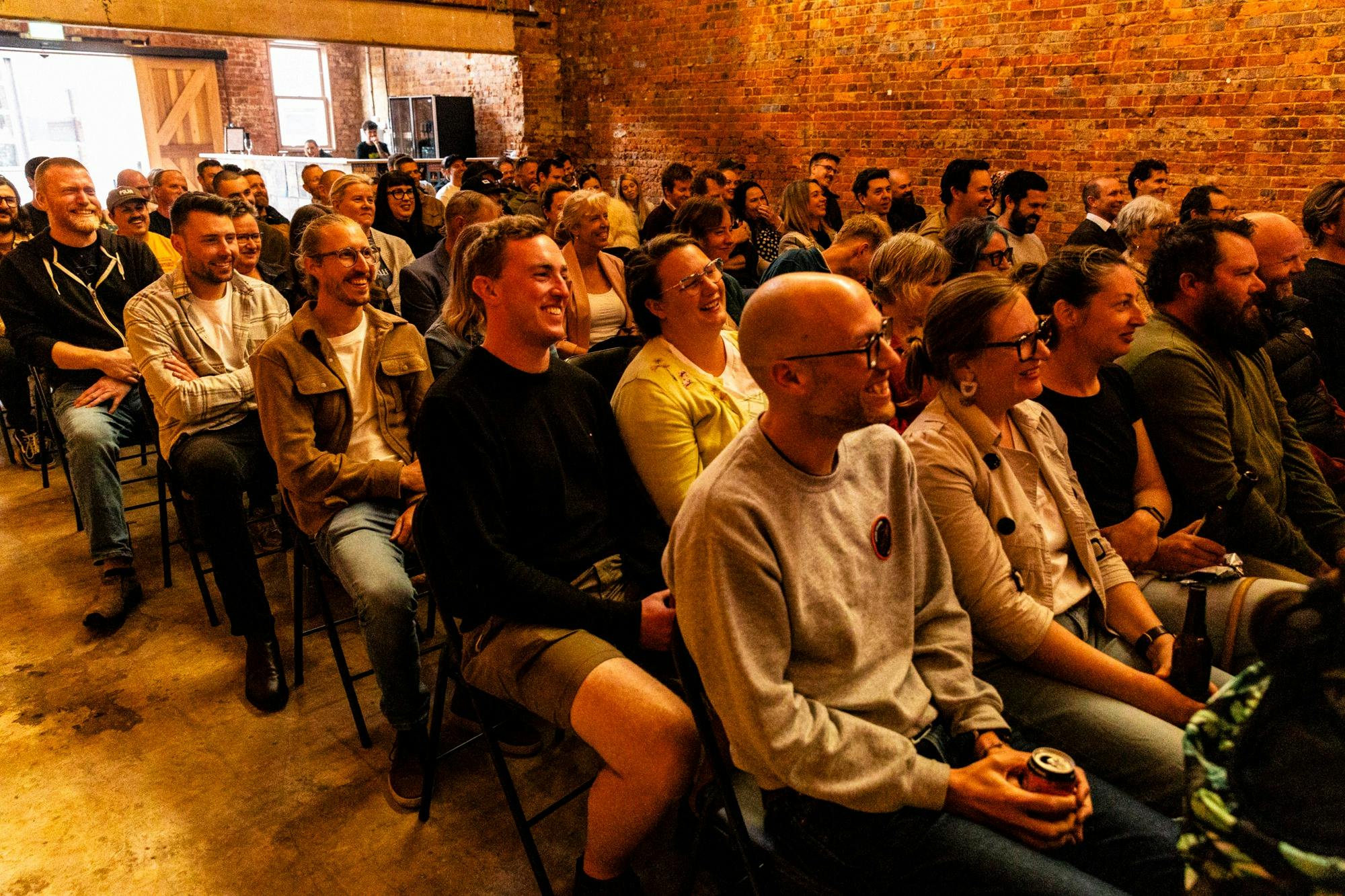 A large crowd seating down and laughing